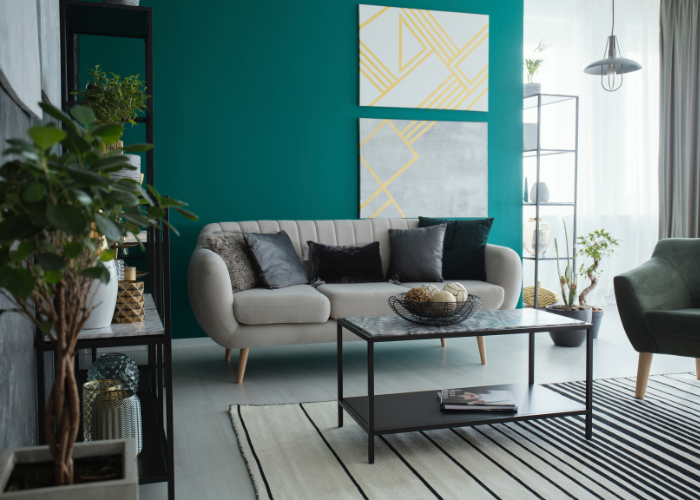 soggiorno con parete color petrolio e divano grigio